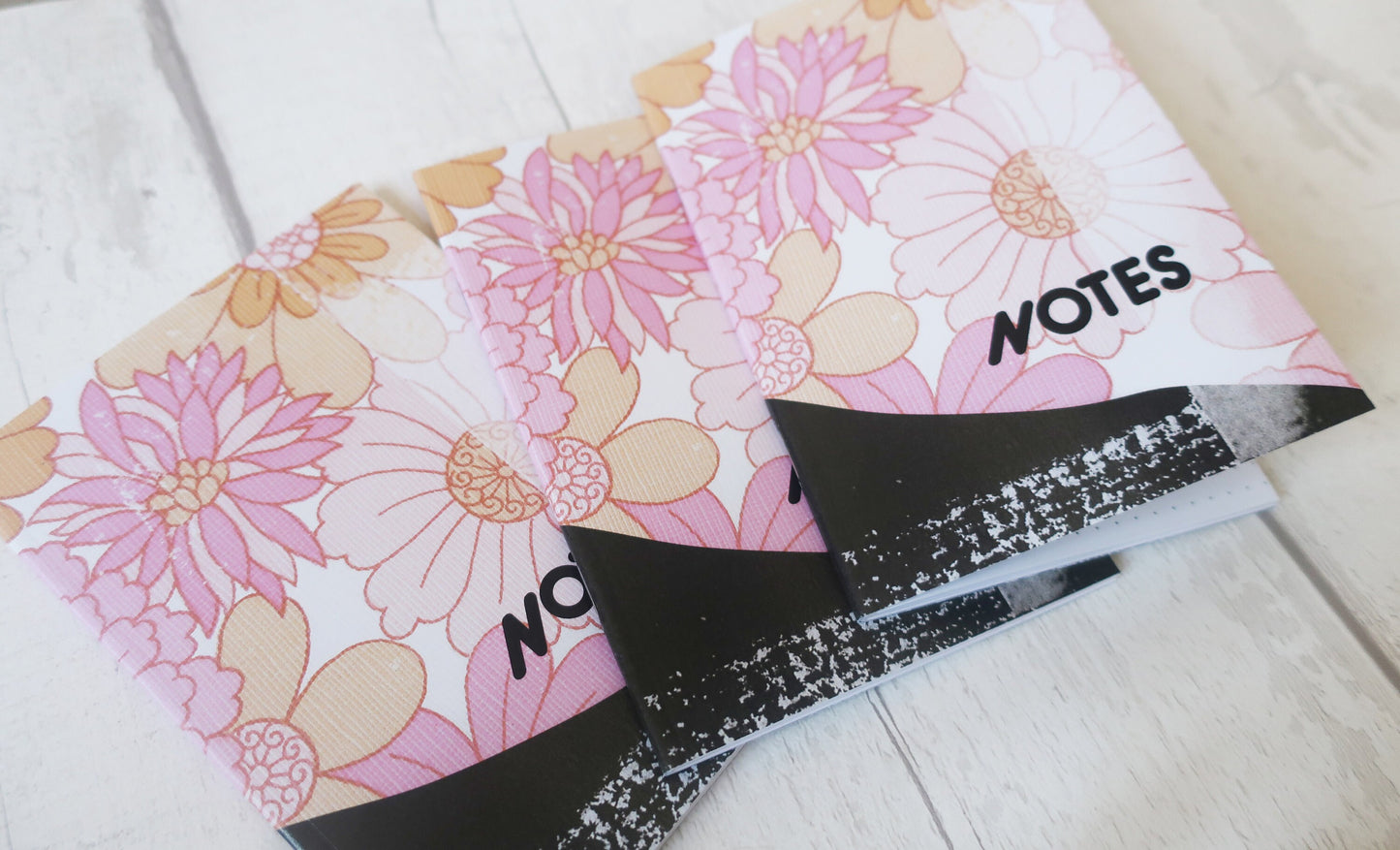 Floral notebook with 'NOTES' label on a light wooden surface