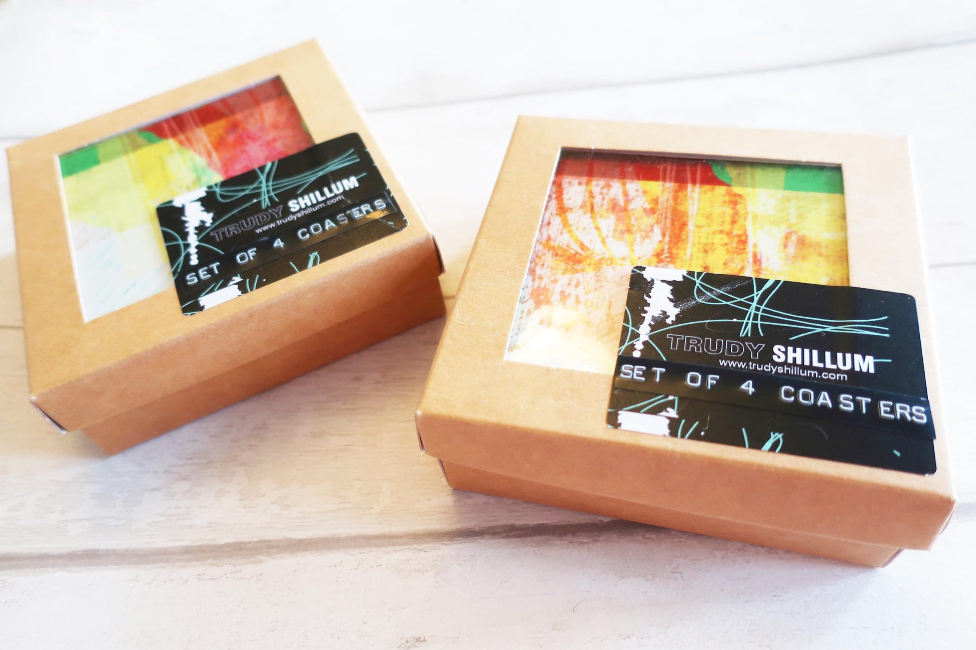 Two boxes containing coasters with visible branding on a light background