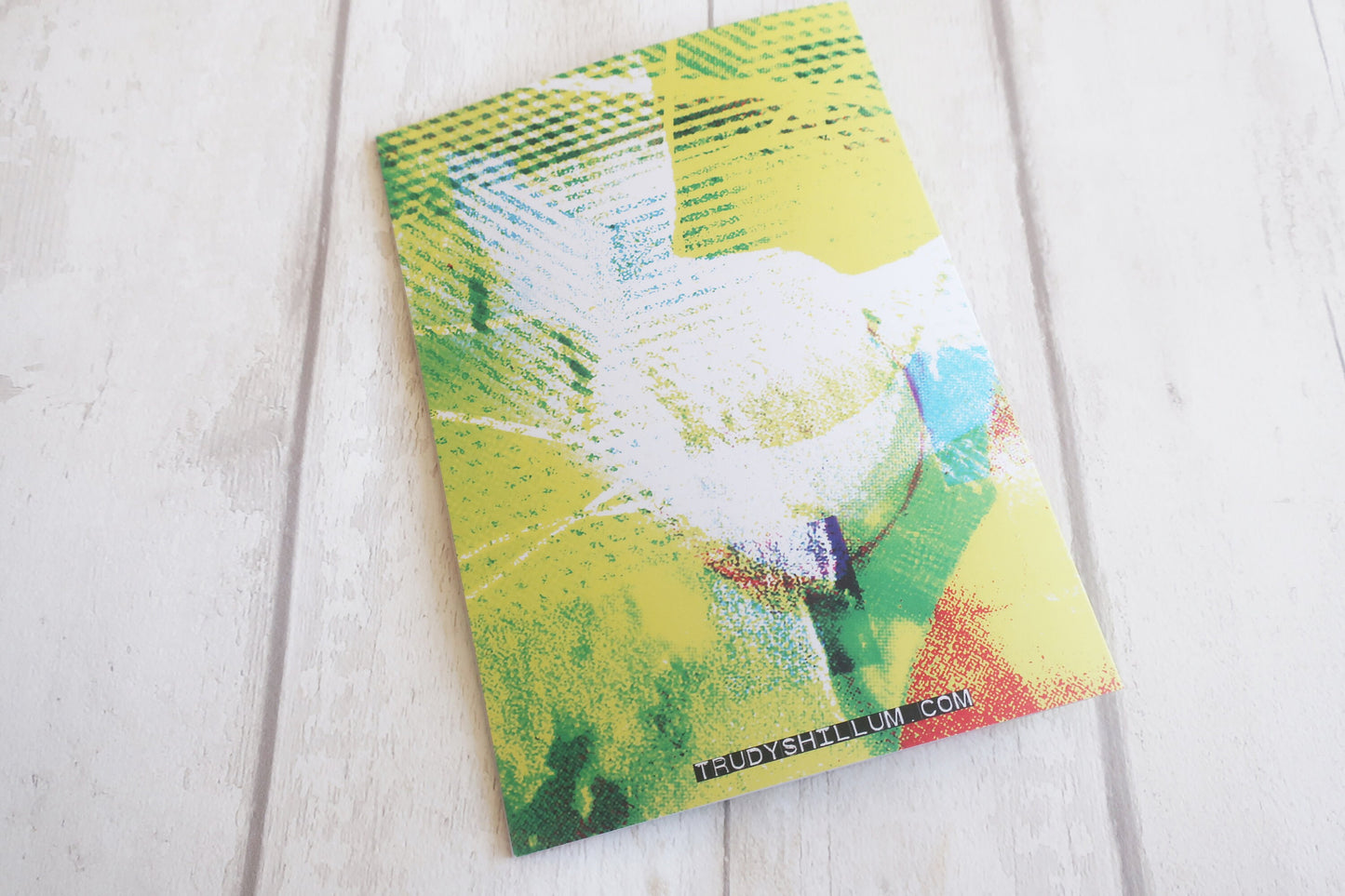 Greeting card with a colorful tree design on a white wooden surface
