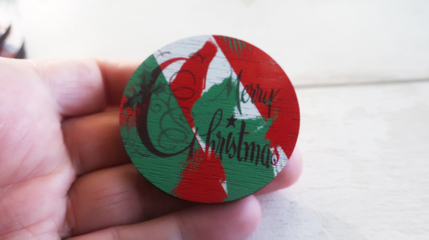 Round Christmas-themed badge held in a hand against a light background