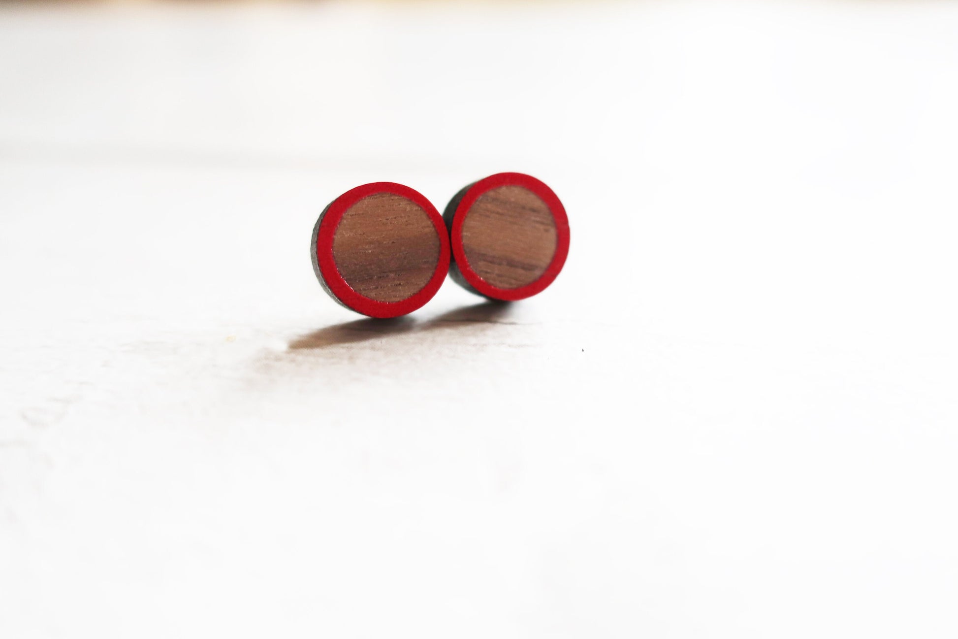 Wooden earrings with red accents on a white background