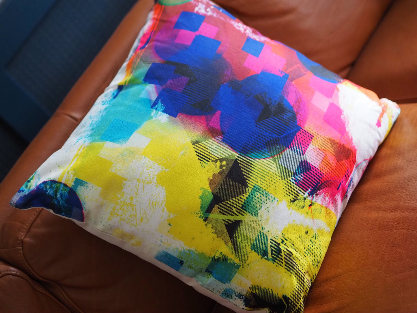 Colorful abstract-patterned pillow on a brown leather couch