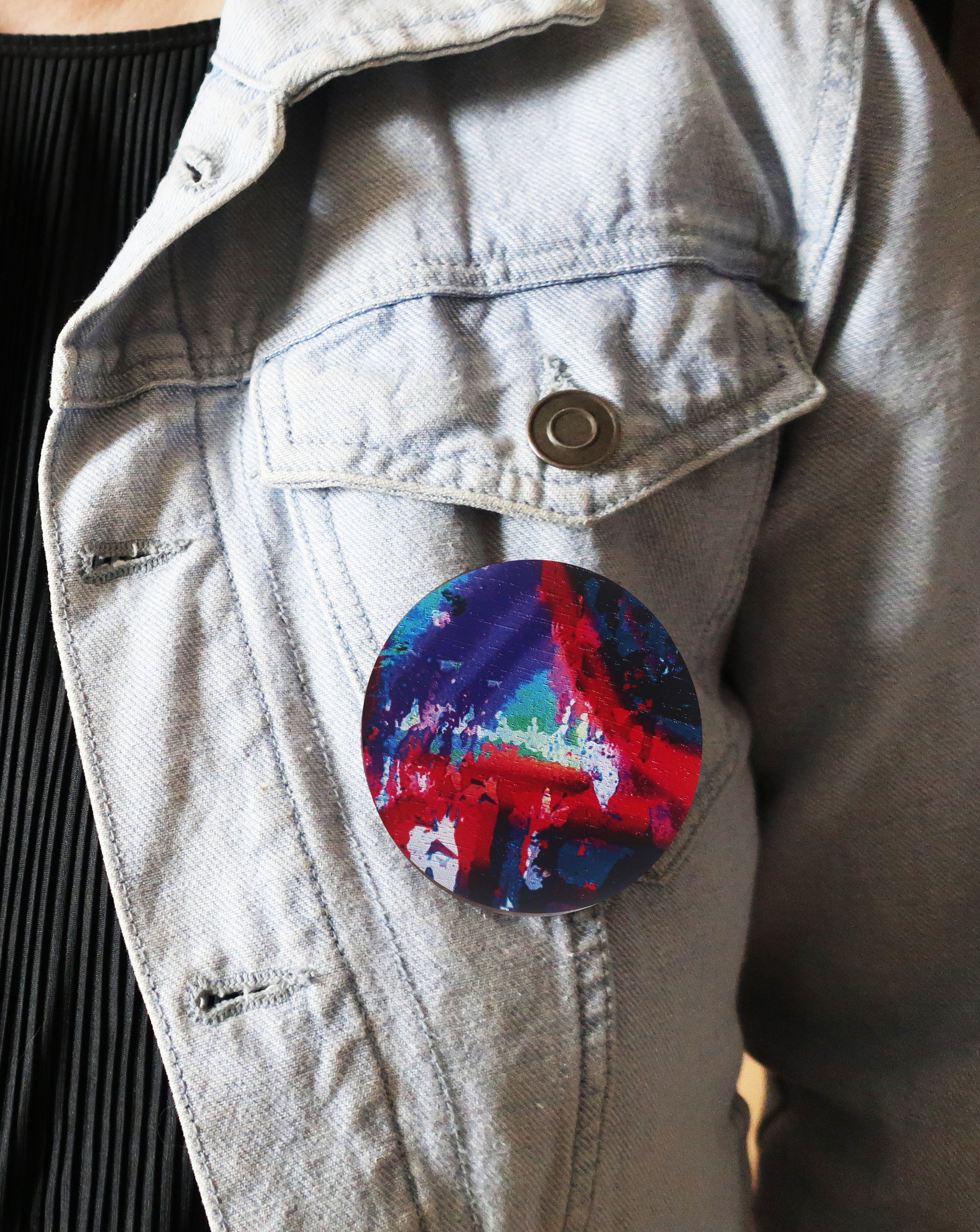 Colorful round brooch  on a light-colored jacket