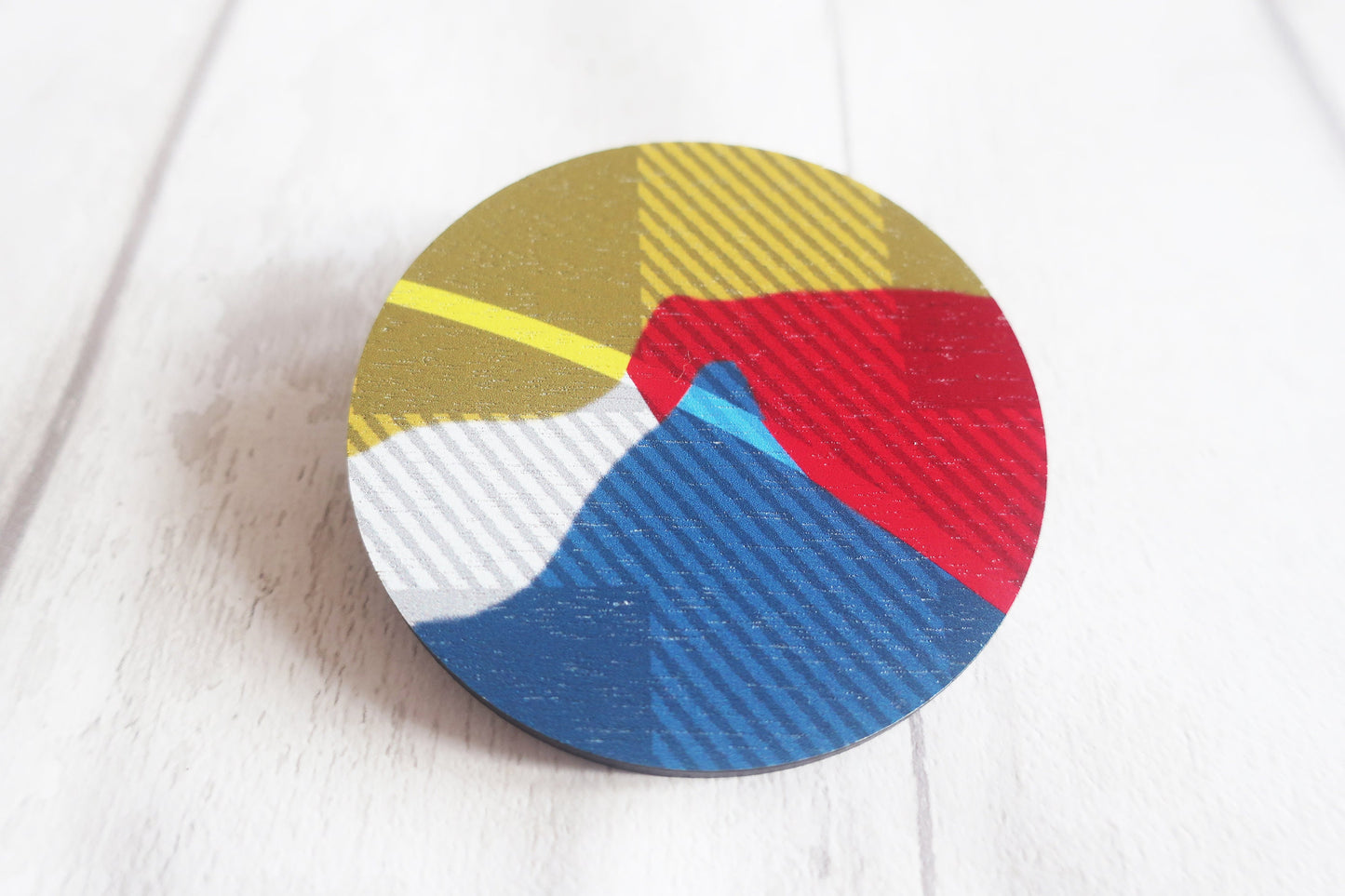 Round brooch with multicolored pattern on a white background