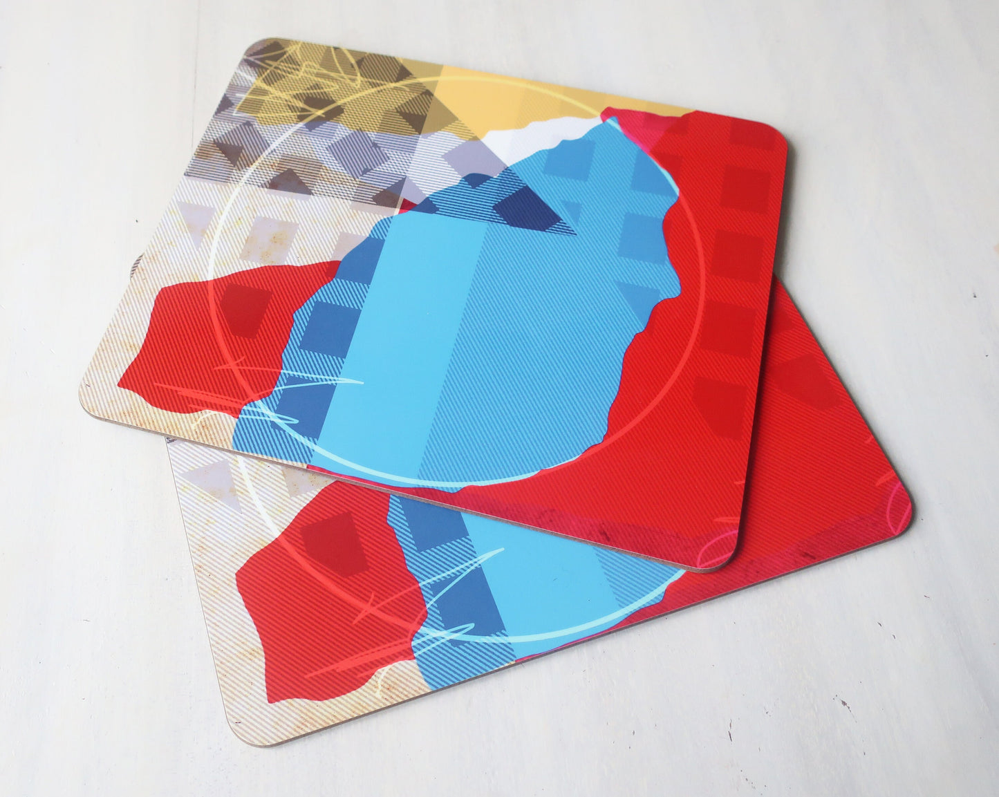 Set of colorful geometric placemats on a light gray surface