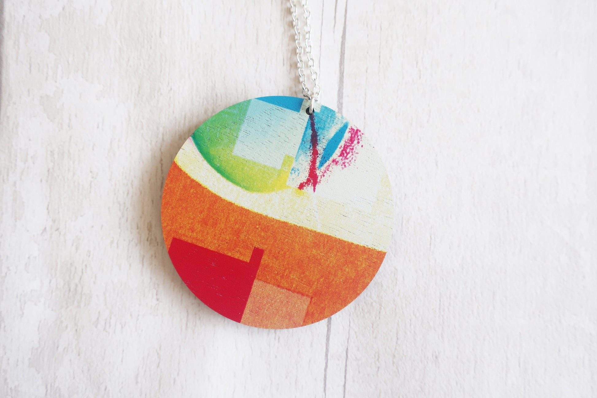 Colorful circular pendant necklace on a white background