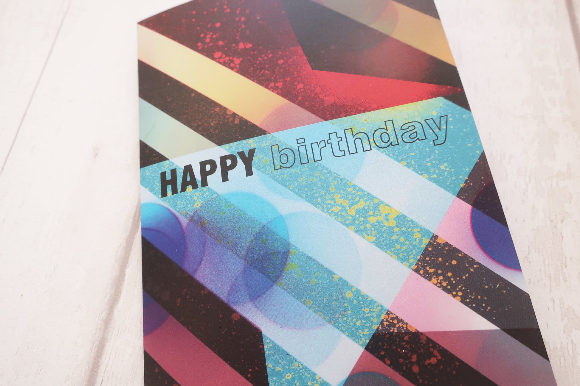 Colorful birthday card with geometric design on a white surface