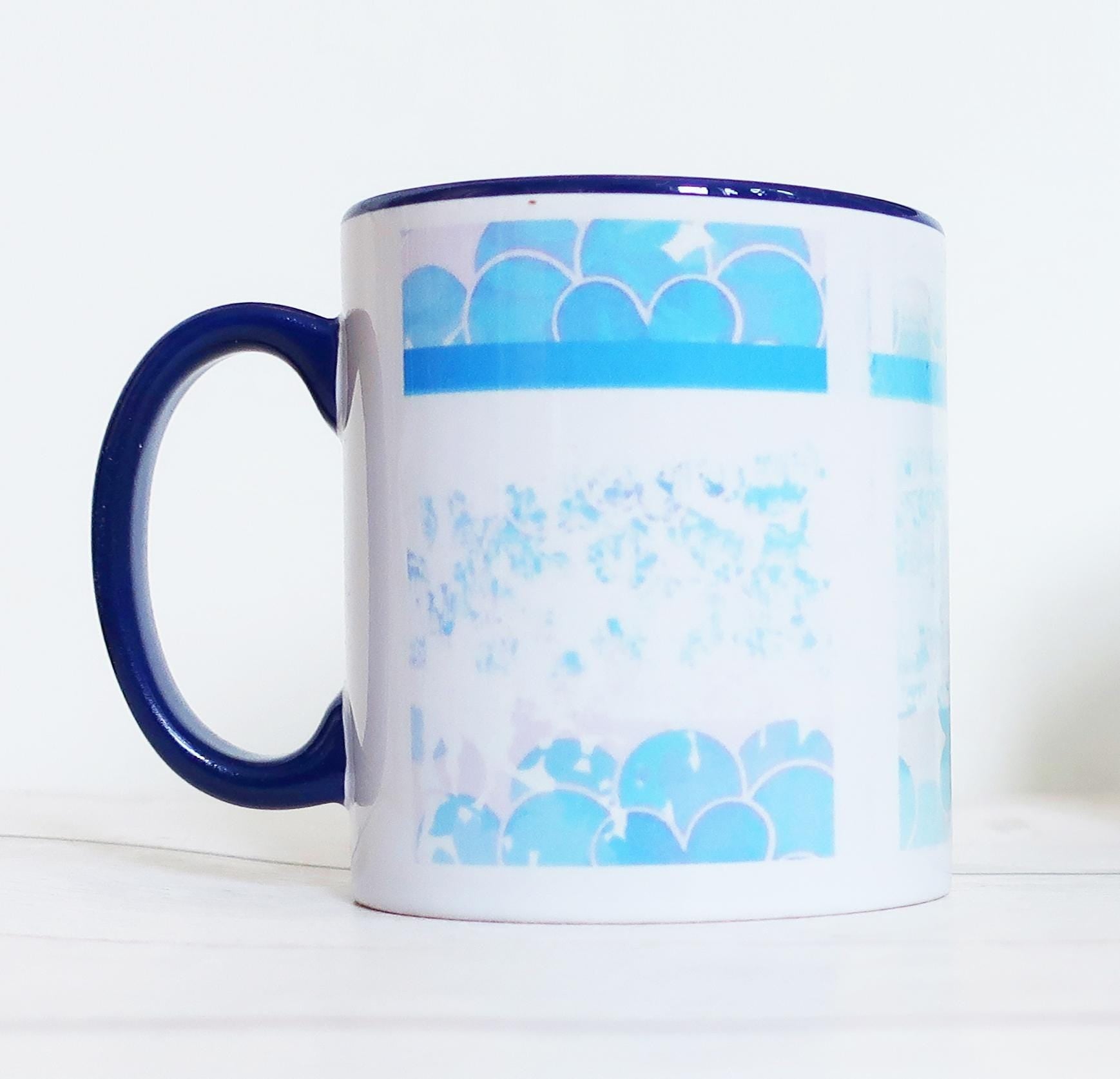 White mug with blue handle and decorative blue patterns on a white background