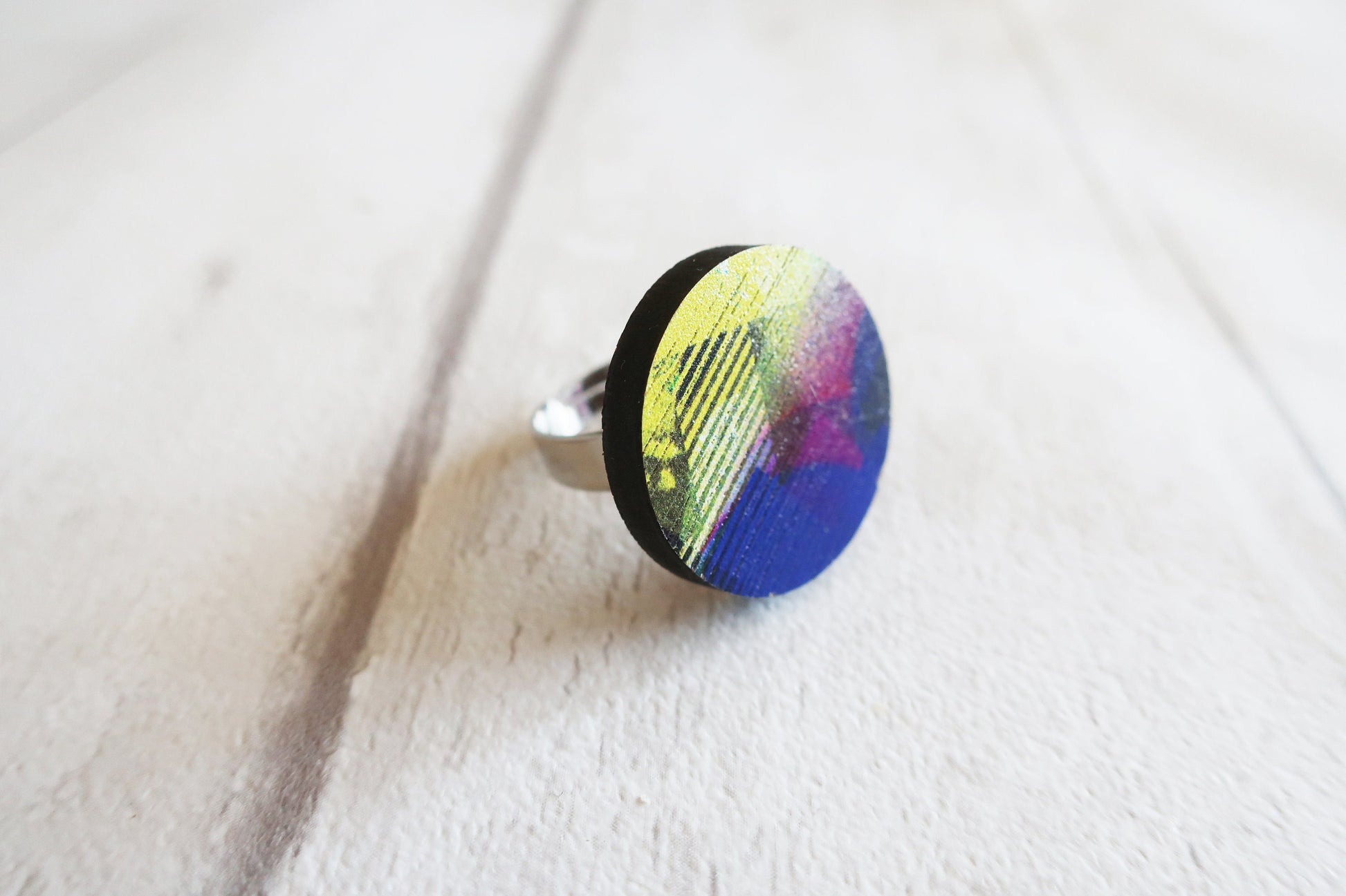 Ring with a colorful design on a white fabric background