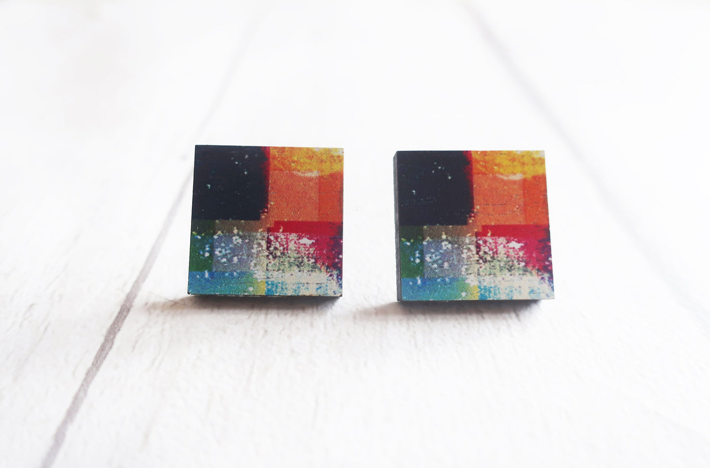 Pair of colorful square earrings on a white background