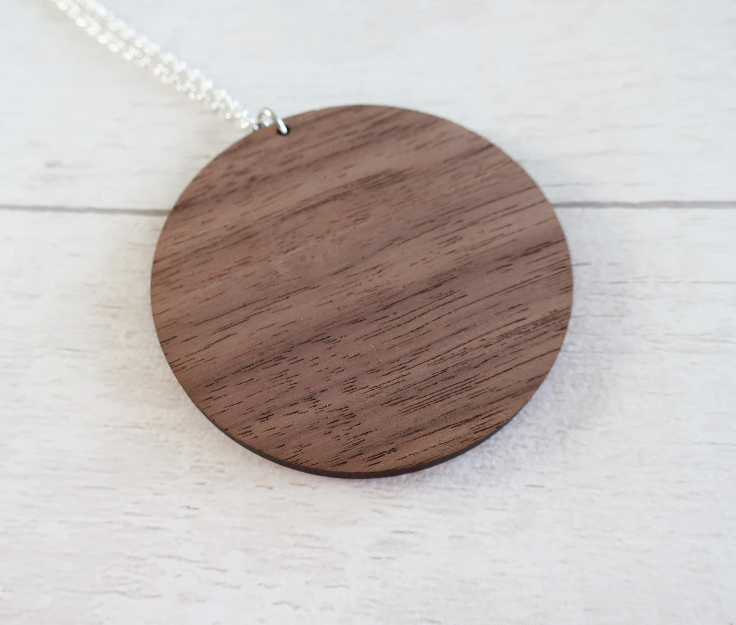 Wooden pendant necklace on a light wooden surface