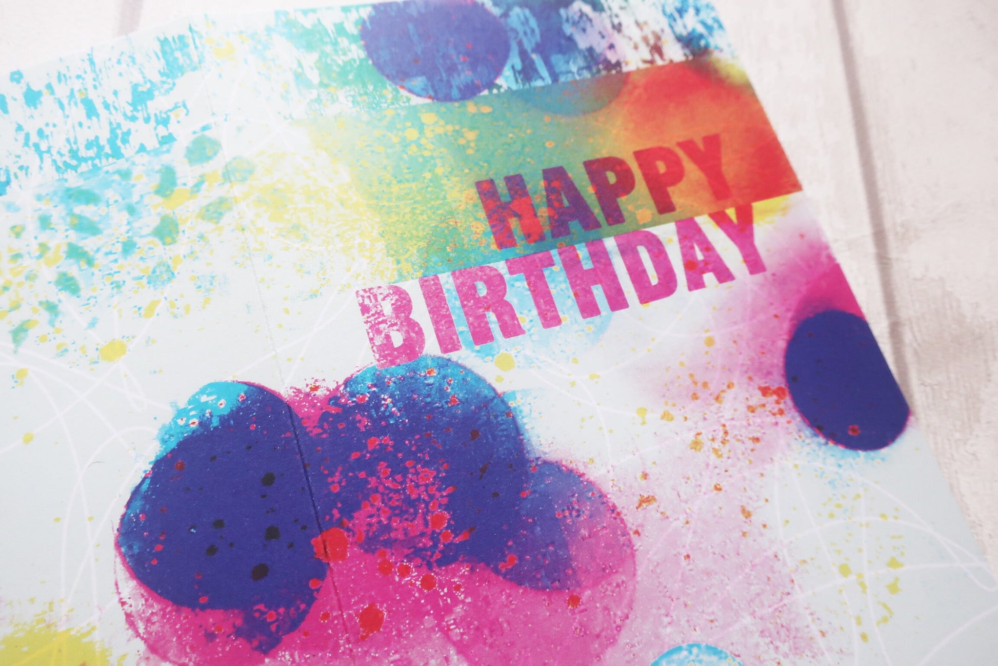 Colorful birthday card with splatter design and 'Happy Birthday' text.