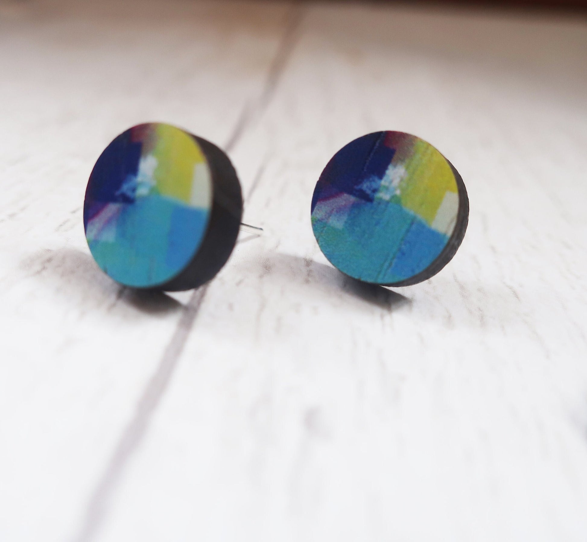 Colorful round earrings on a light background