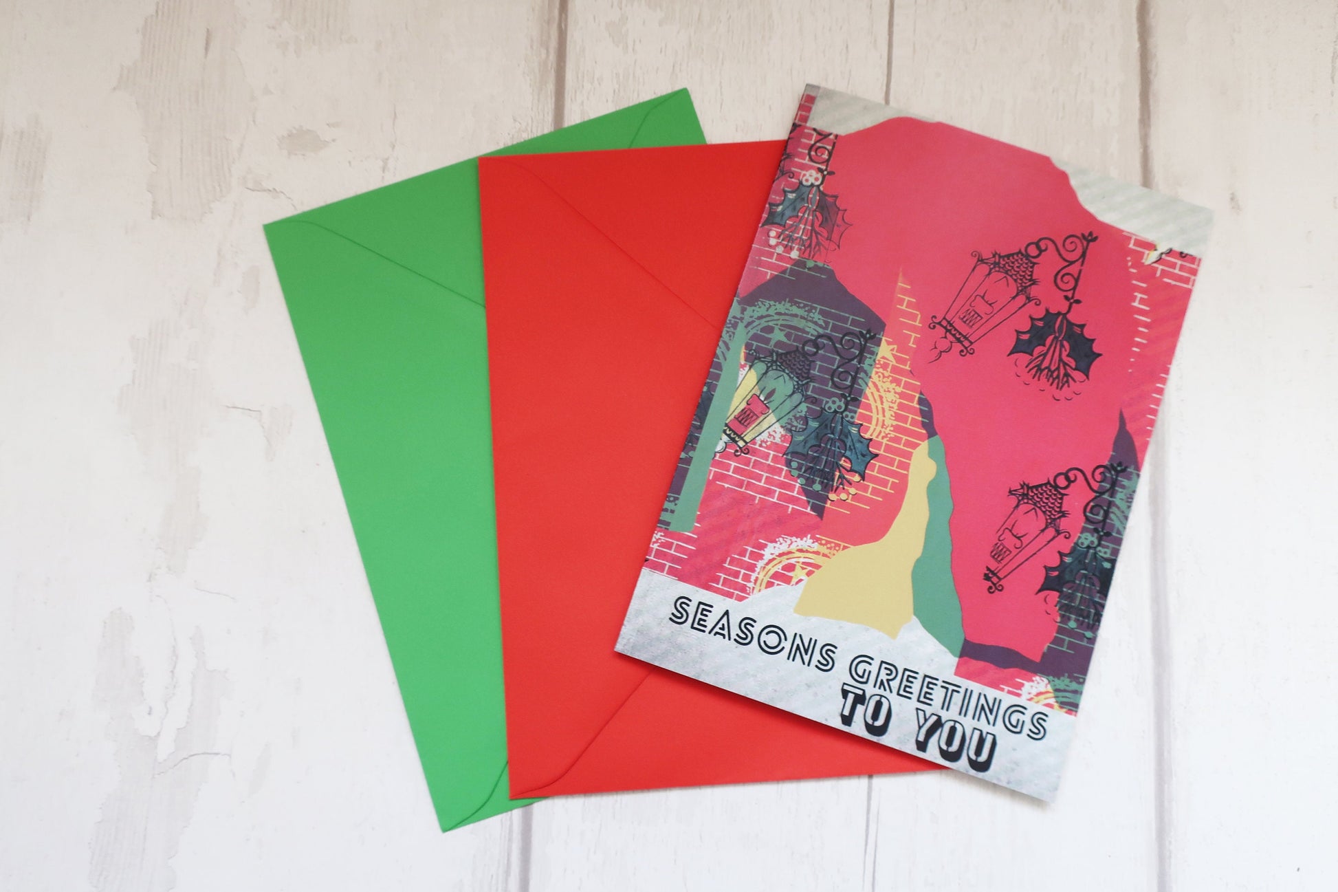 Colorful greeting cards and envelopes on a light wooden surface