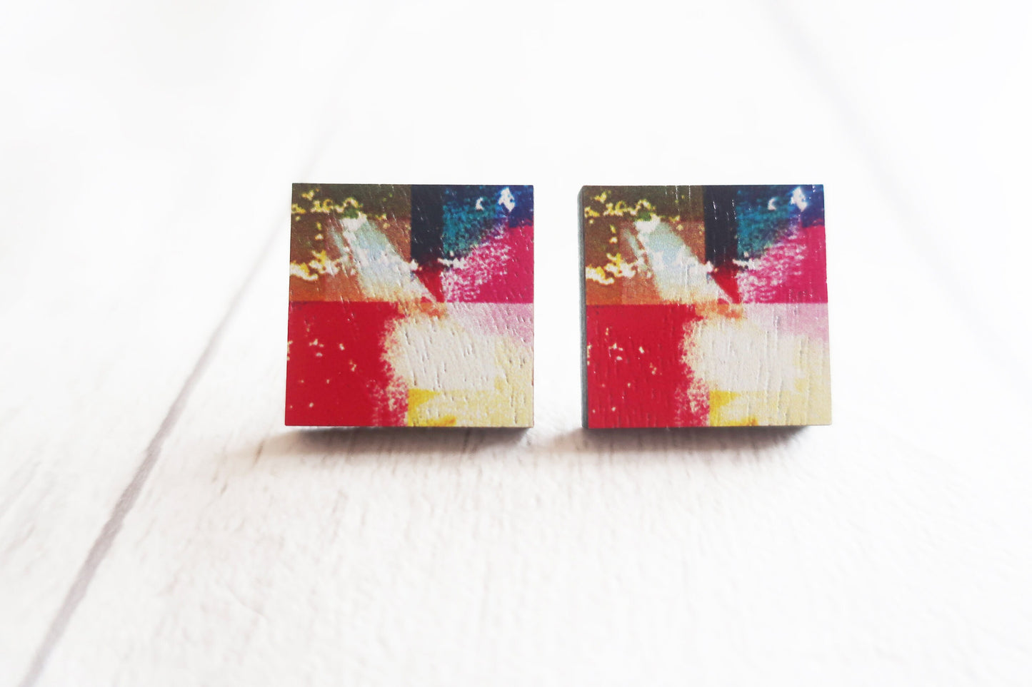 Pair of colorful square earrings on a white background