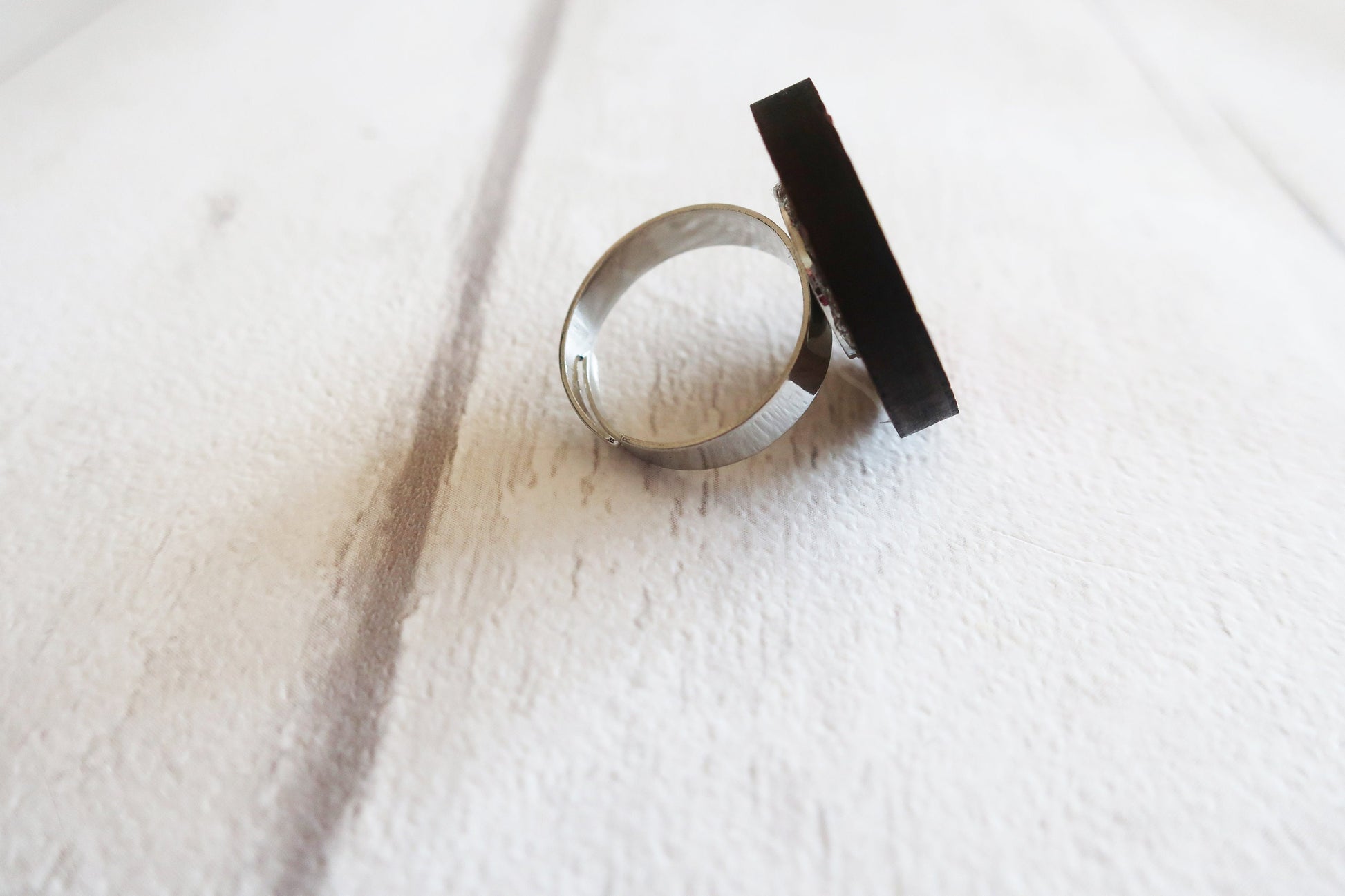 Silver ring with a black band on a white fabric background