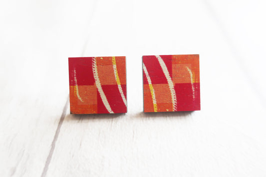 Pair of square earrings with red, orange, and white pattern on a white background