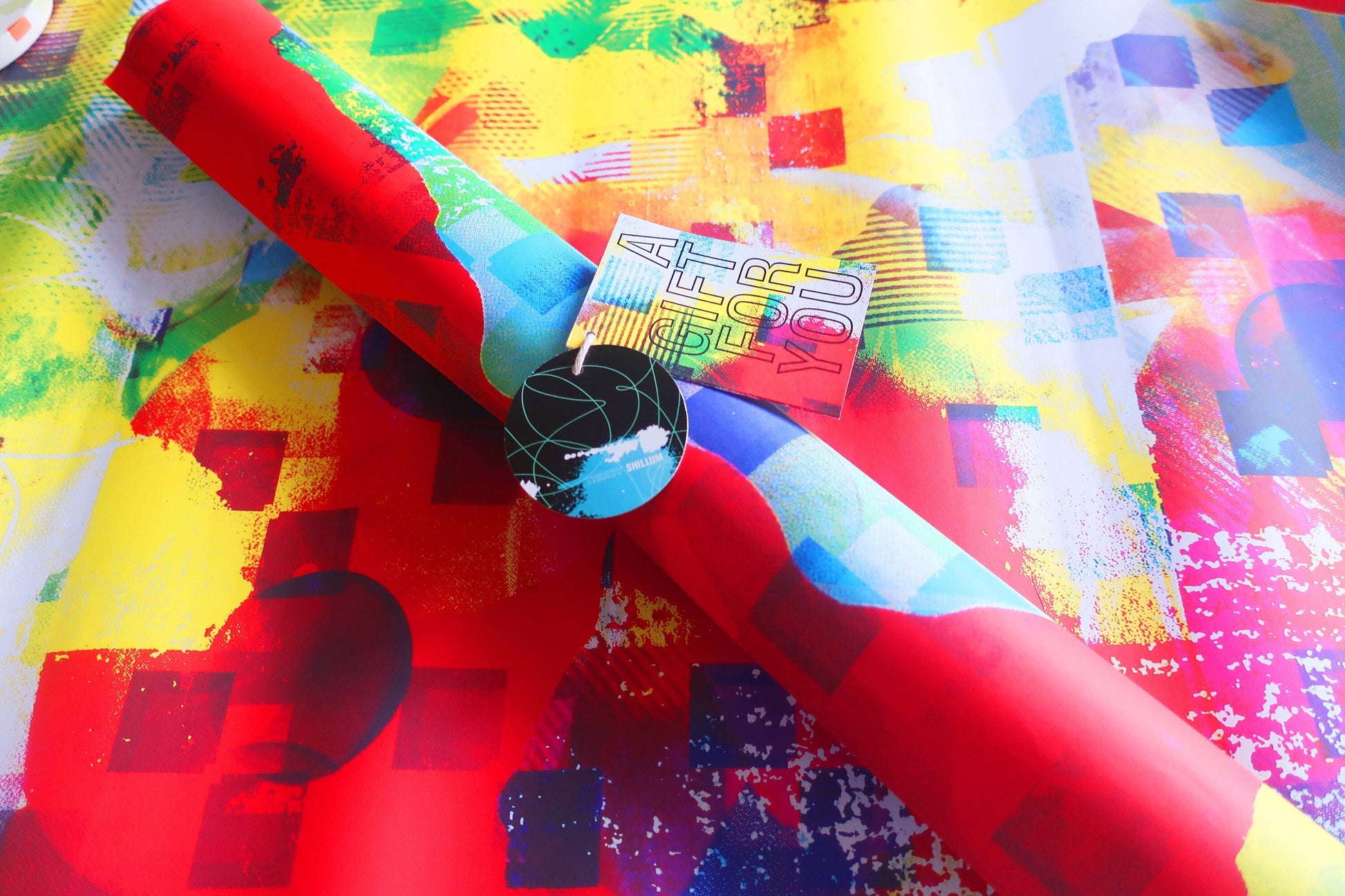 Colorful paper with abstract patterns and a black circular label on top