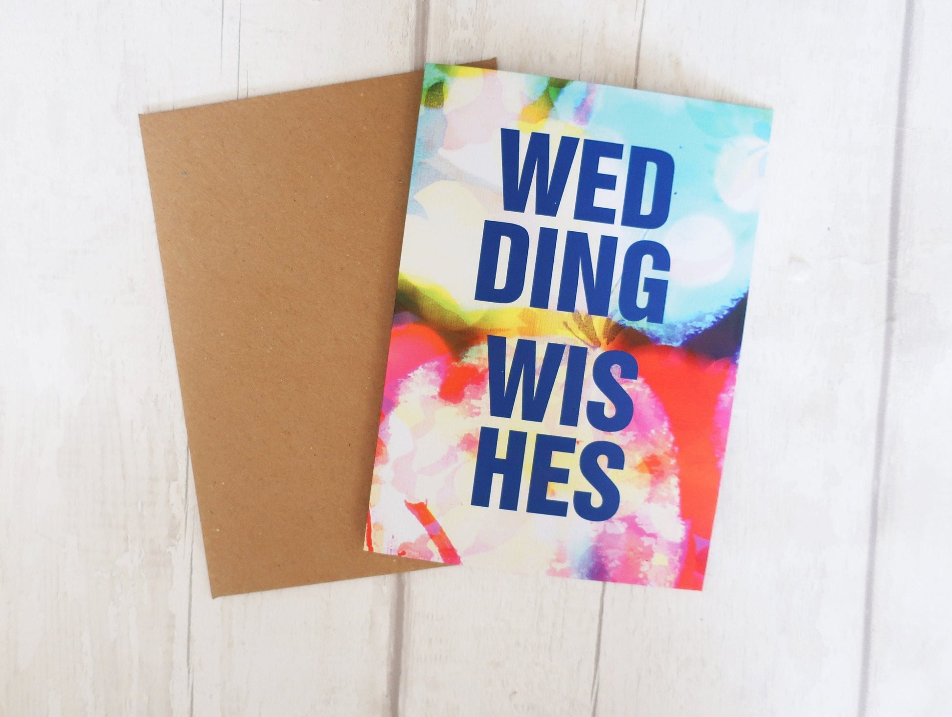 Colorful card with 'Wedding Wishes' text on a wooden surface