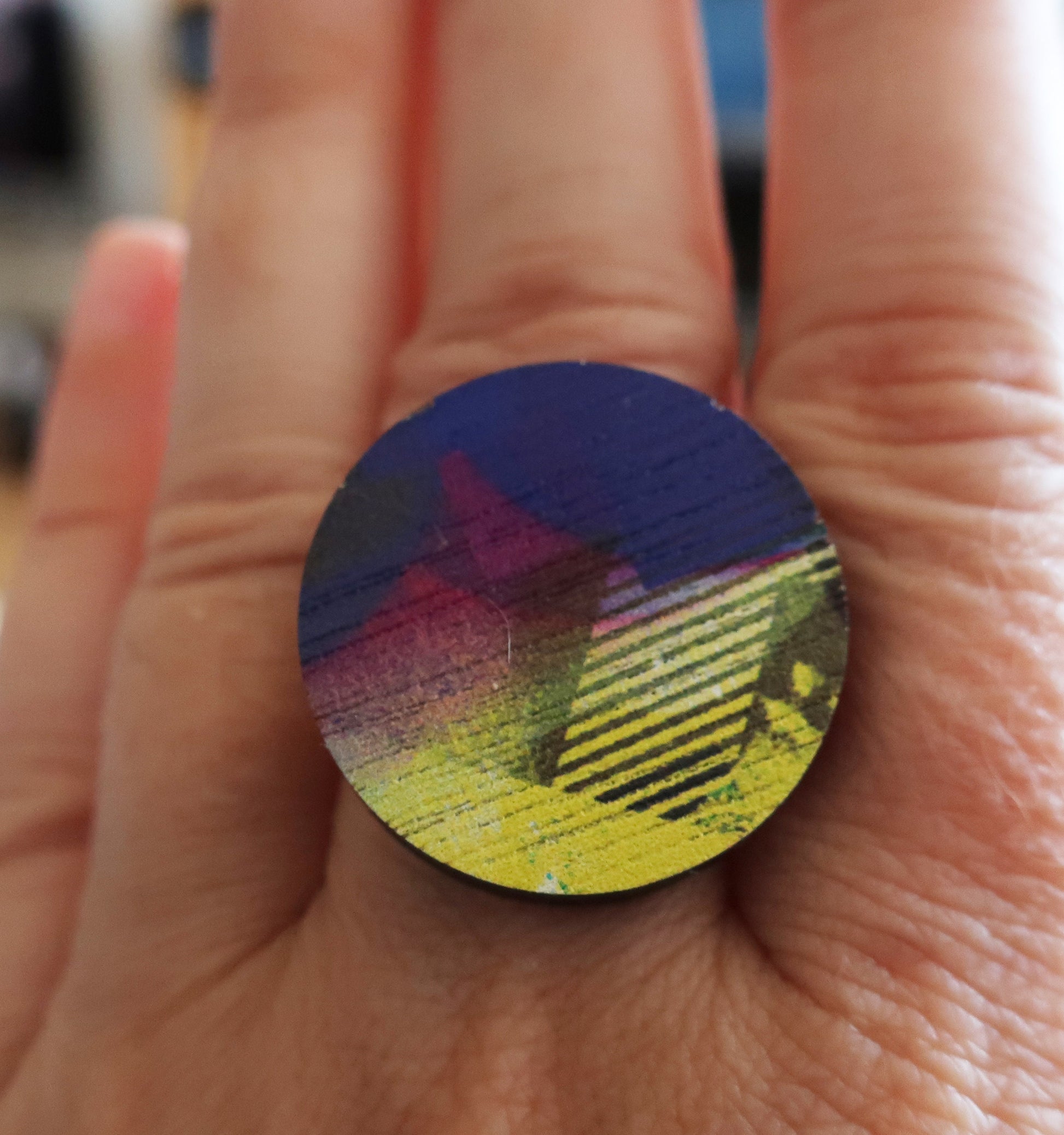 Round colorful ring held between fingers