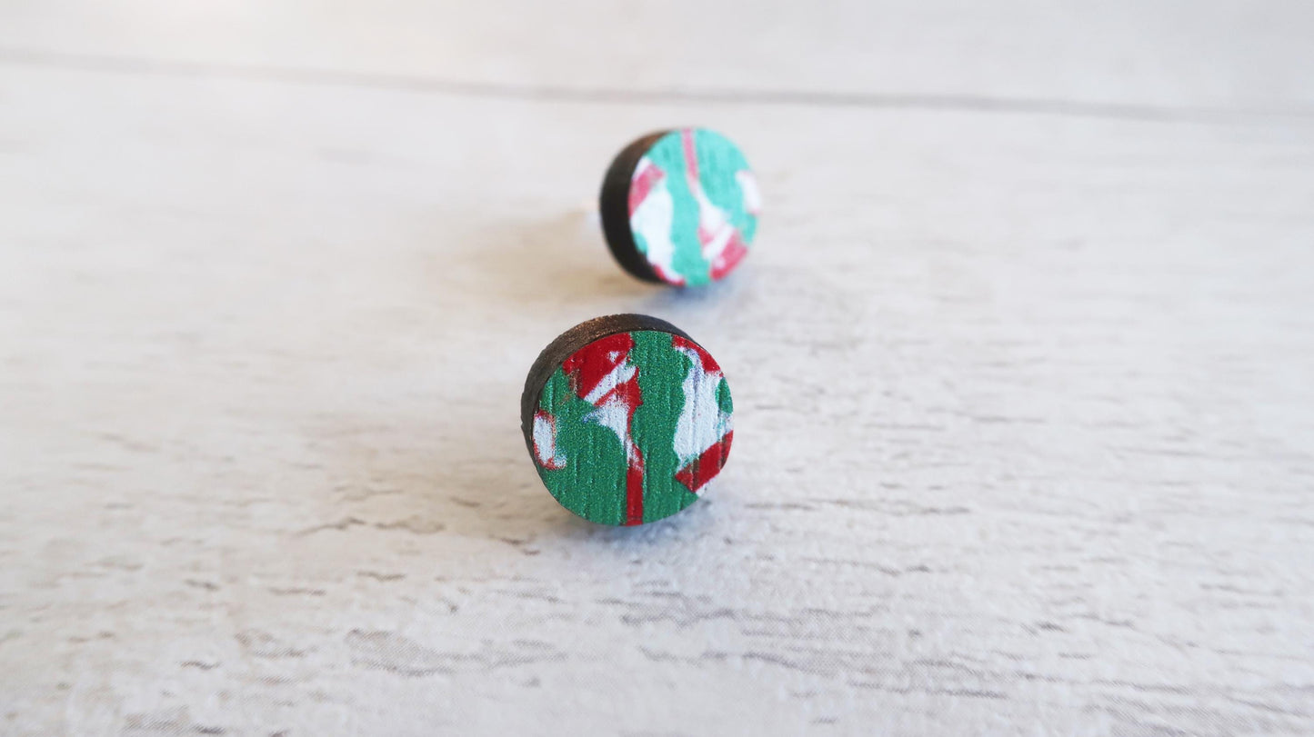 Pair of round earrings with colorful patterns on a light wooden surface
