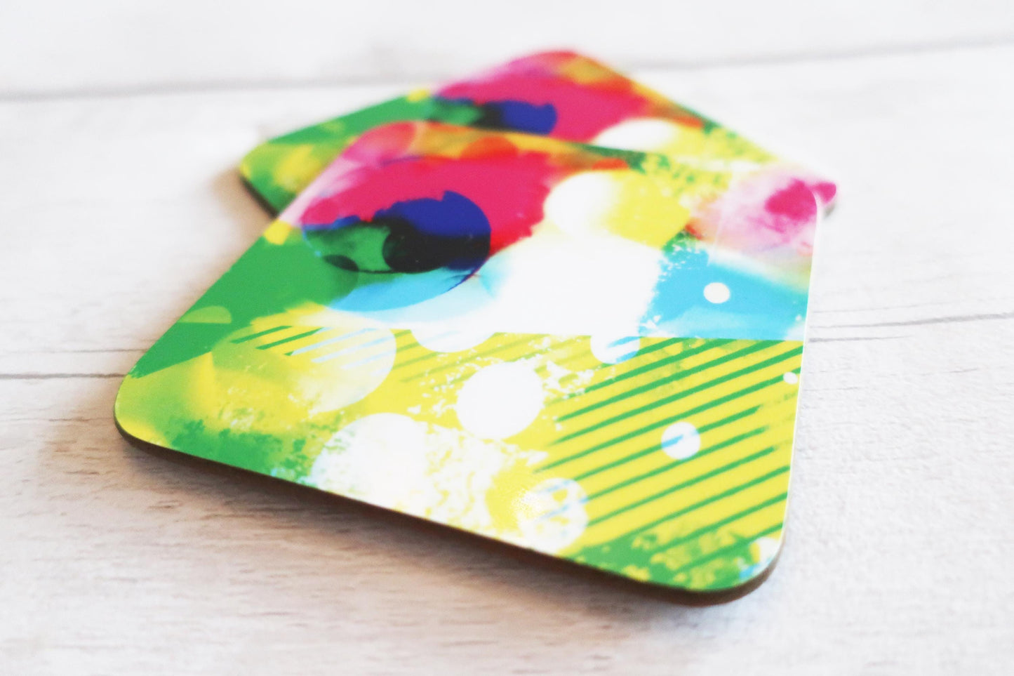 Colorful abstract design coaster on a wooden surface