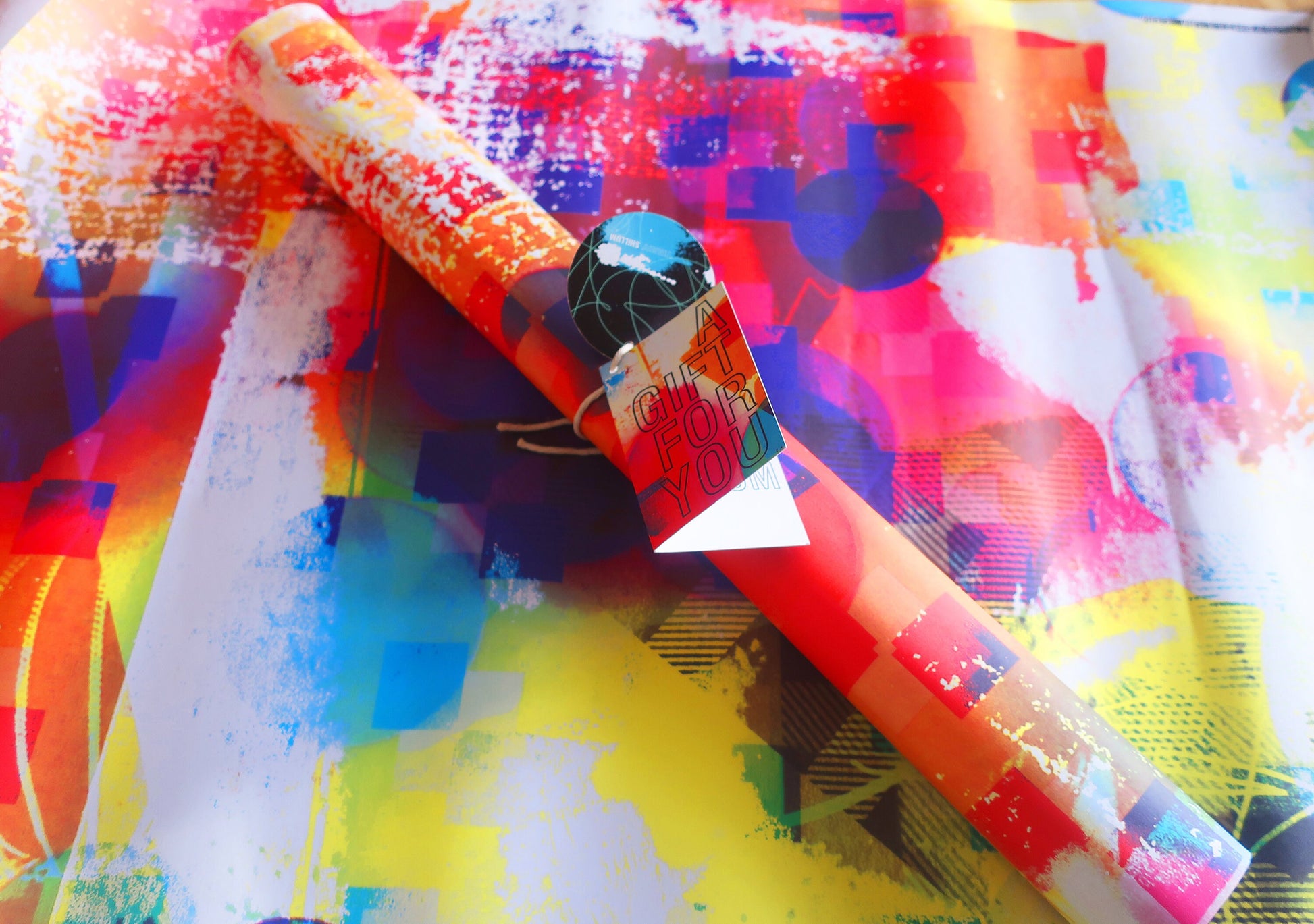 Colorful abstract wrapping paper with a roll of paper and a box on top