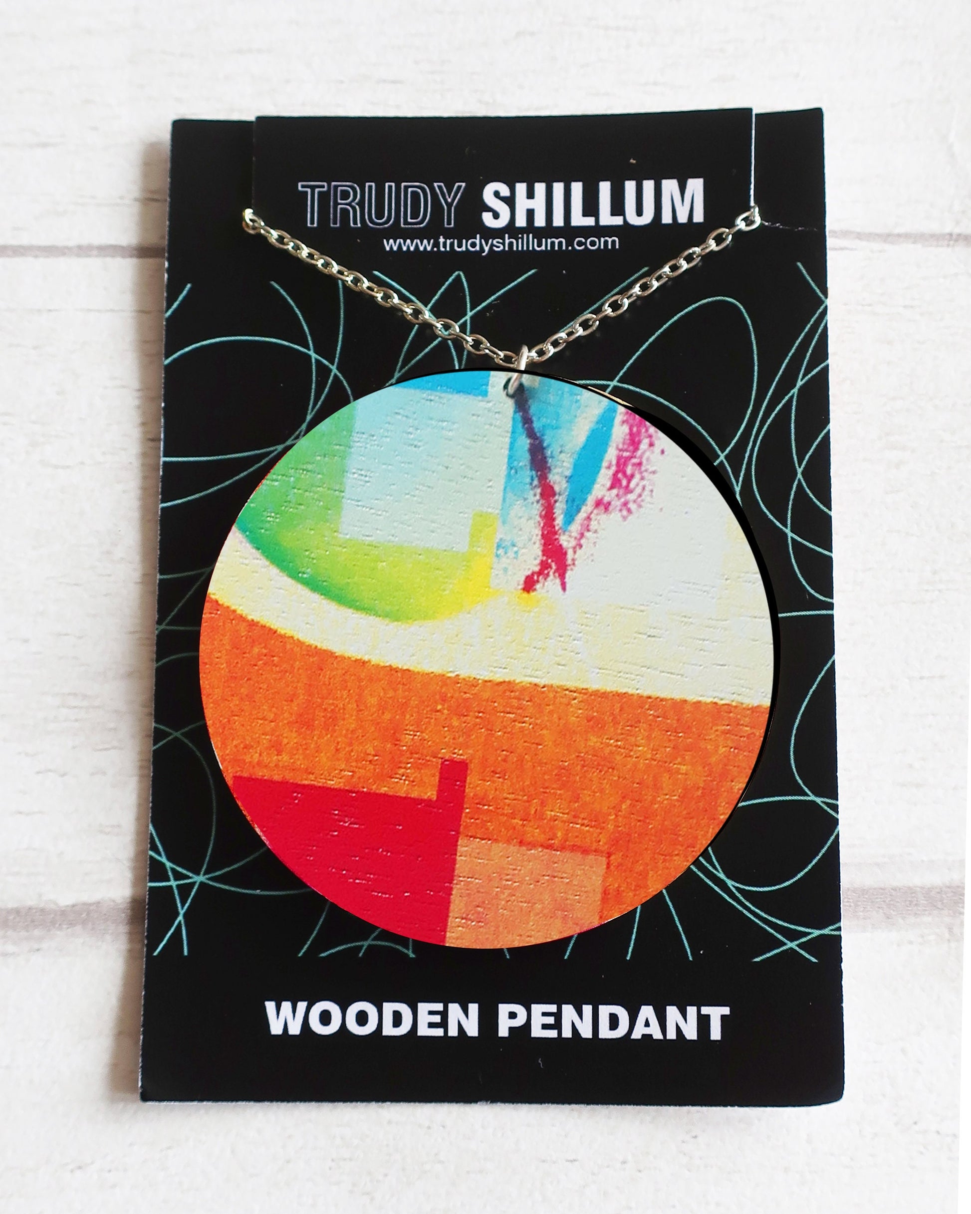 Colorful wooden pendant on a Trudy Shillum branded card