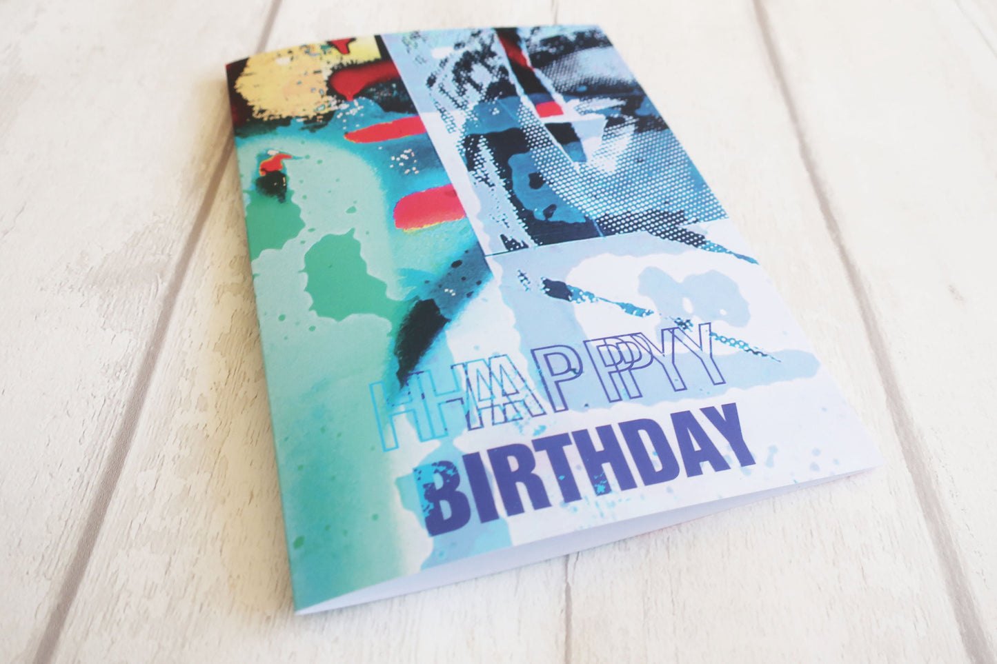 Colorful birthday card with abstract designs on a light wooden surface