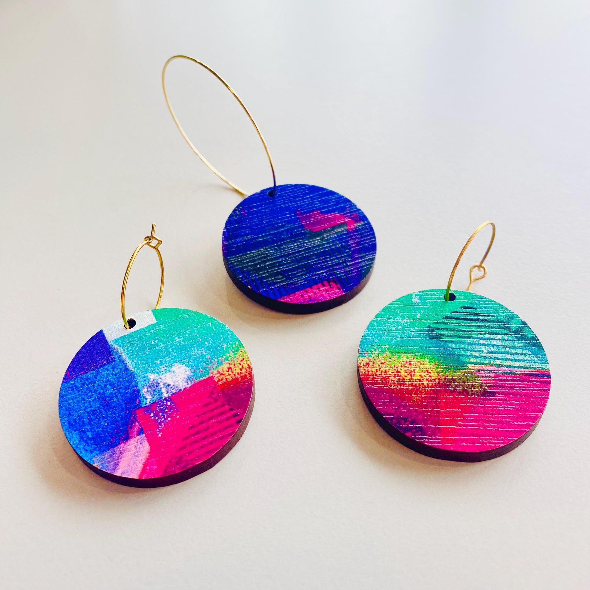 Colorful round earrings on a light gray background