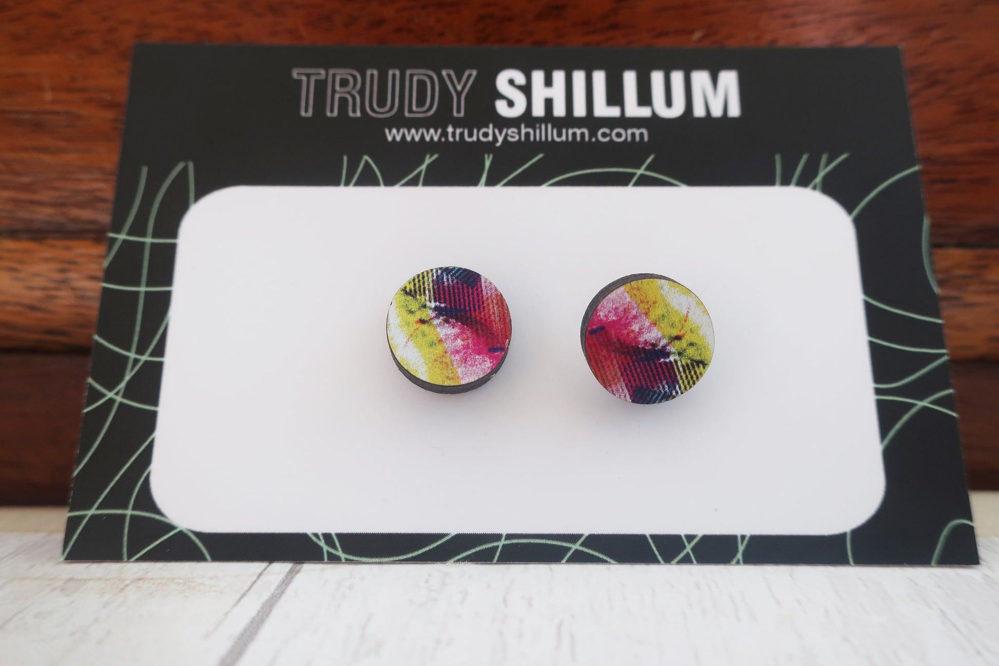 Colorful round earrings on a Trudy Shillum branded card.