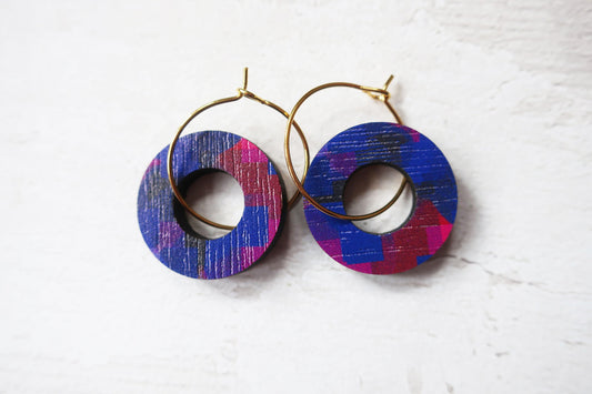Pair of hoop earrings with colorful circular designs on a white background