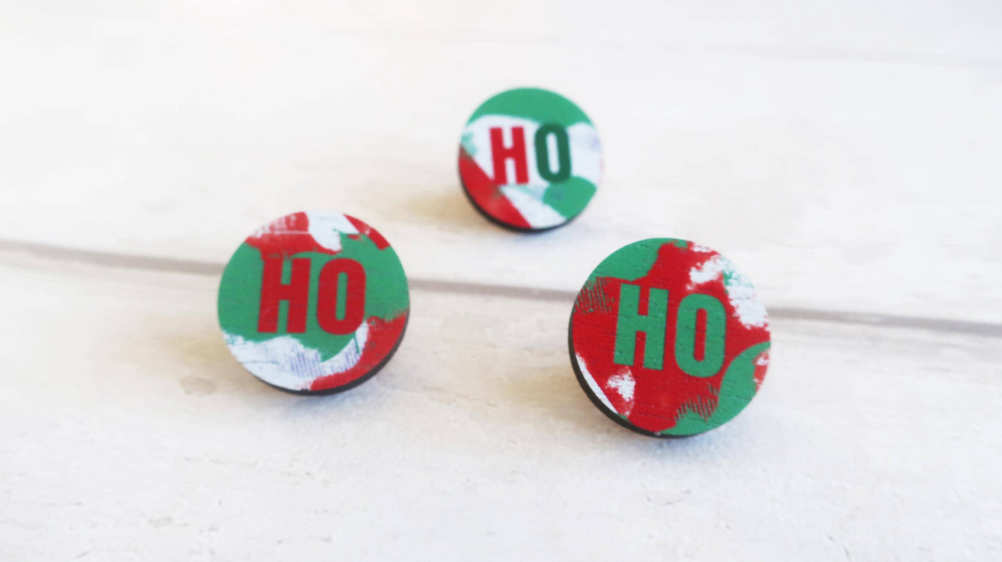 Three round red and green pin badges with 'HO' text on a white background