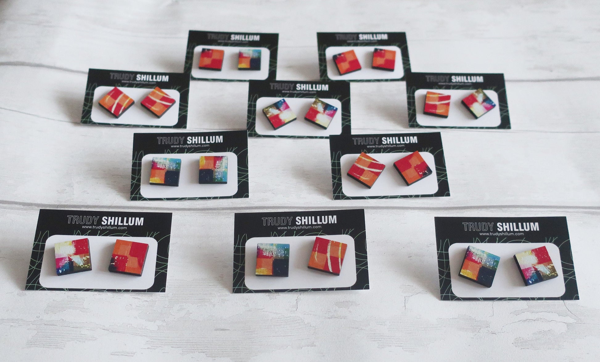 Multiple pairs of earrings in display cards on a white surface