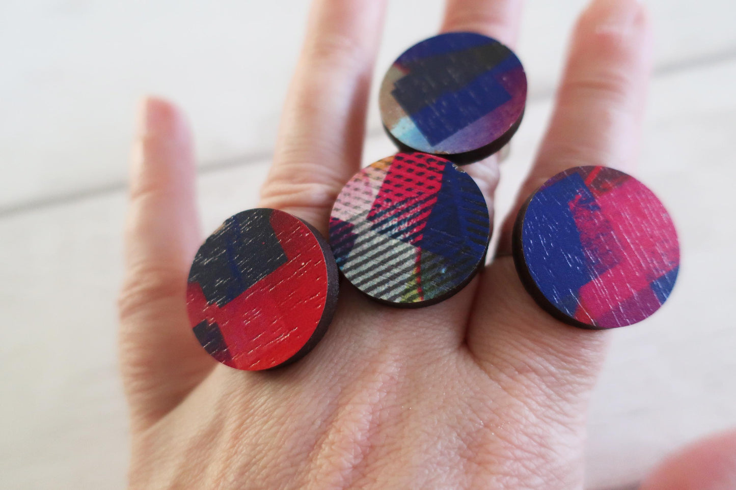 Colorful round rings held in a hand against a neutral background