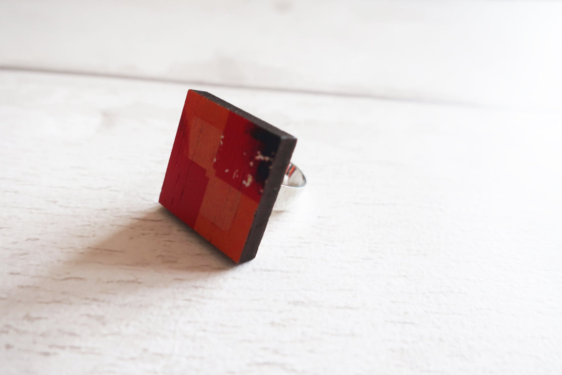 Square orange ring on a white wooden surface