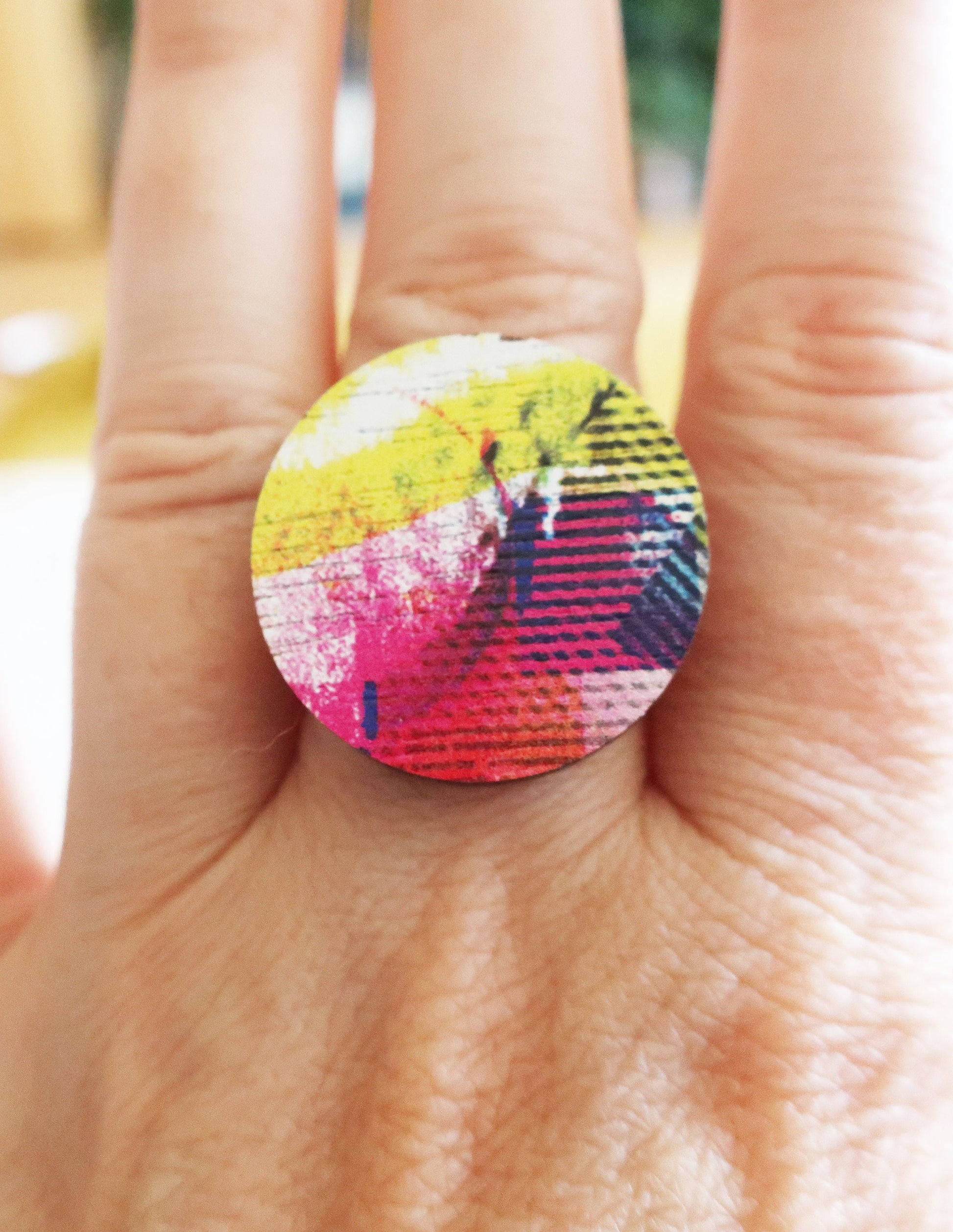 Colorful ring on a finger with a blurred background