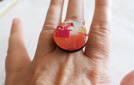 Hand wearing a colorful ring on a white background