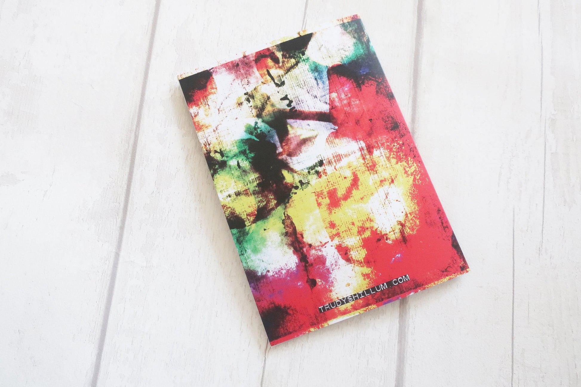 Colorful abstract card back on a white wooden surface