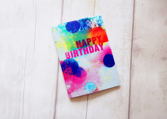 Colorful birthday card with watercolor design on a light wooden surface
