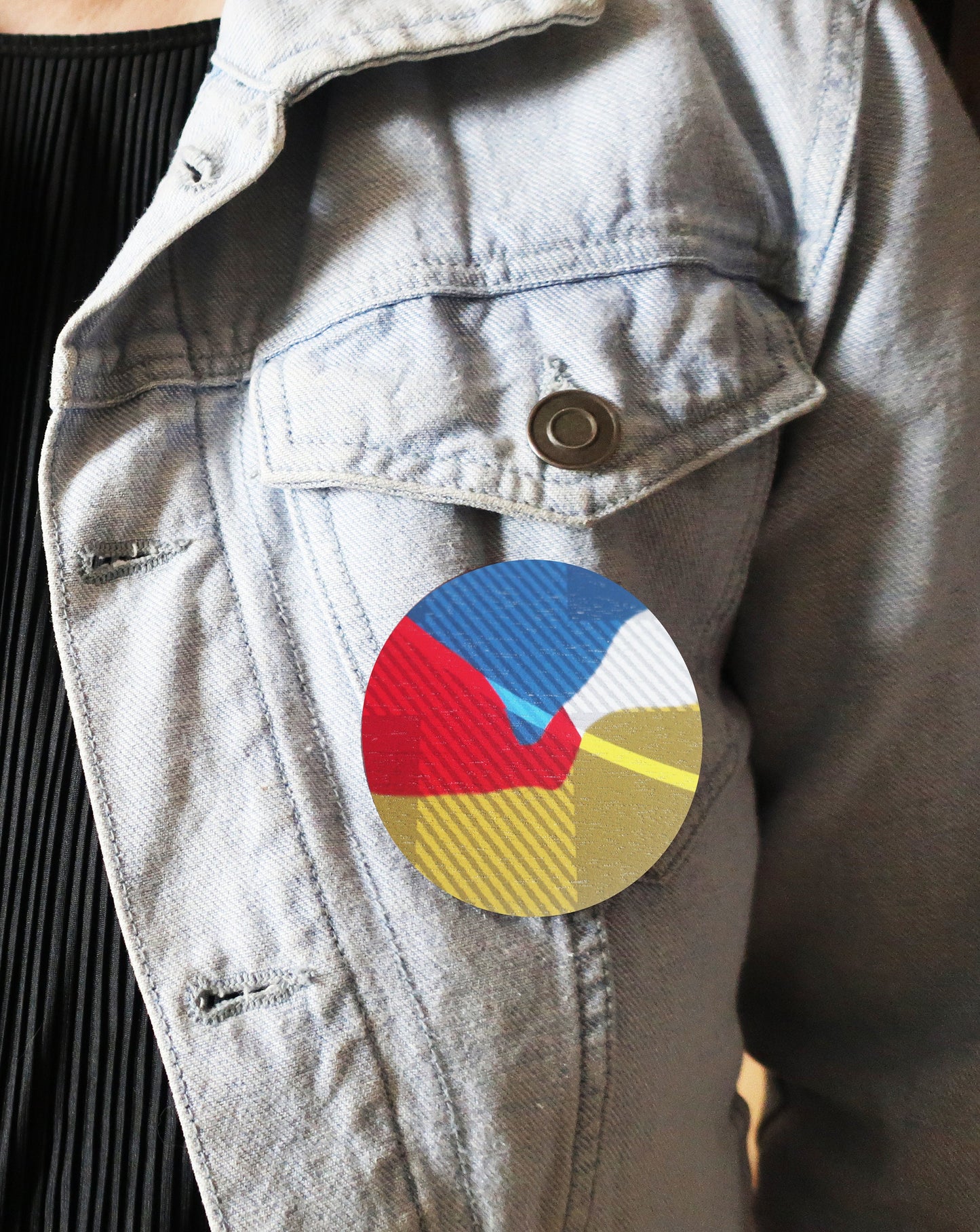 Colorful circular brooch on a denim jacket
