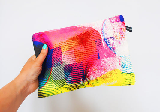Colorful pouch held by a hand against a white background