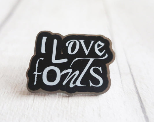 I love fonts pin in black and white on a white wooden surface