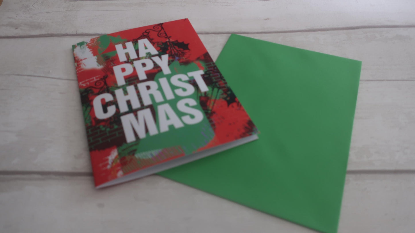 Christmas-themed card and green envelope on a wooden surface