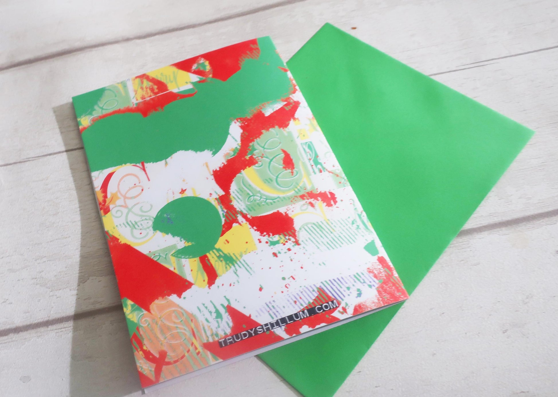 Colorful card with a green envelope on a light wooden surface