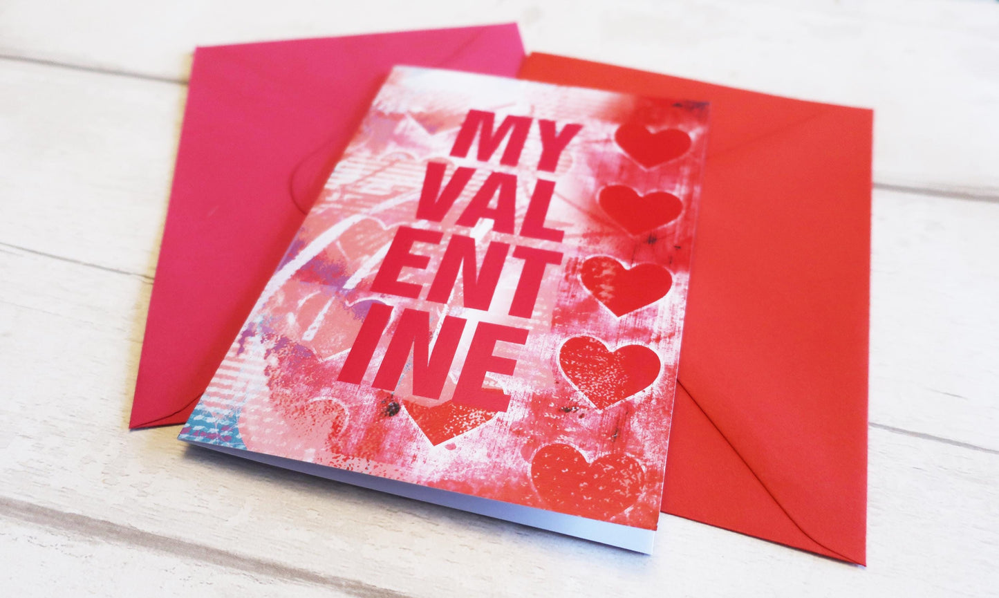 Valentine's Day card with red hearts and 'My Valentine' text, placed on a wooden surface.