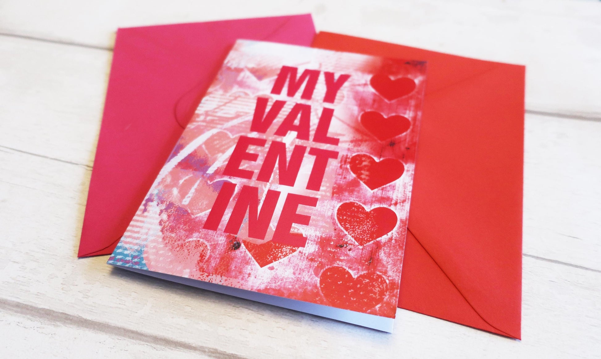 Valentine's Day card with red hearts and 'My Valentine' text, placed on a wooden surface.