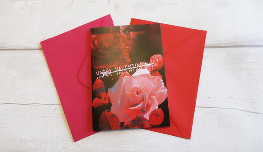Valentine's Day card with red envelope on a white wooden surface