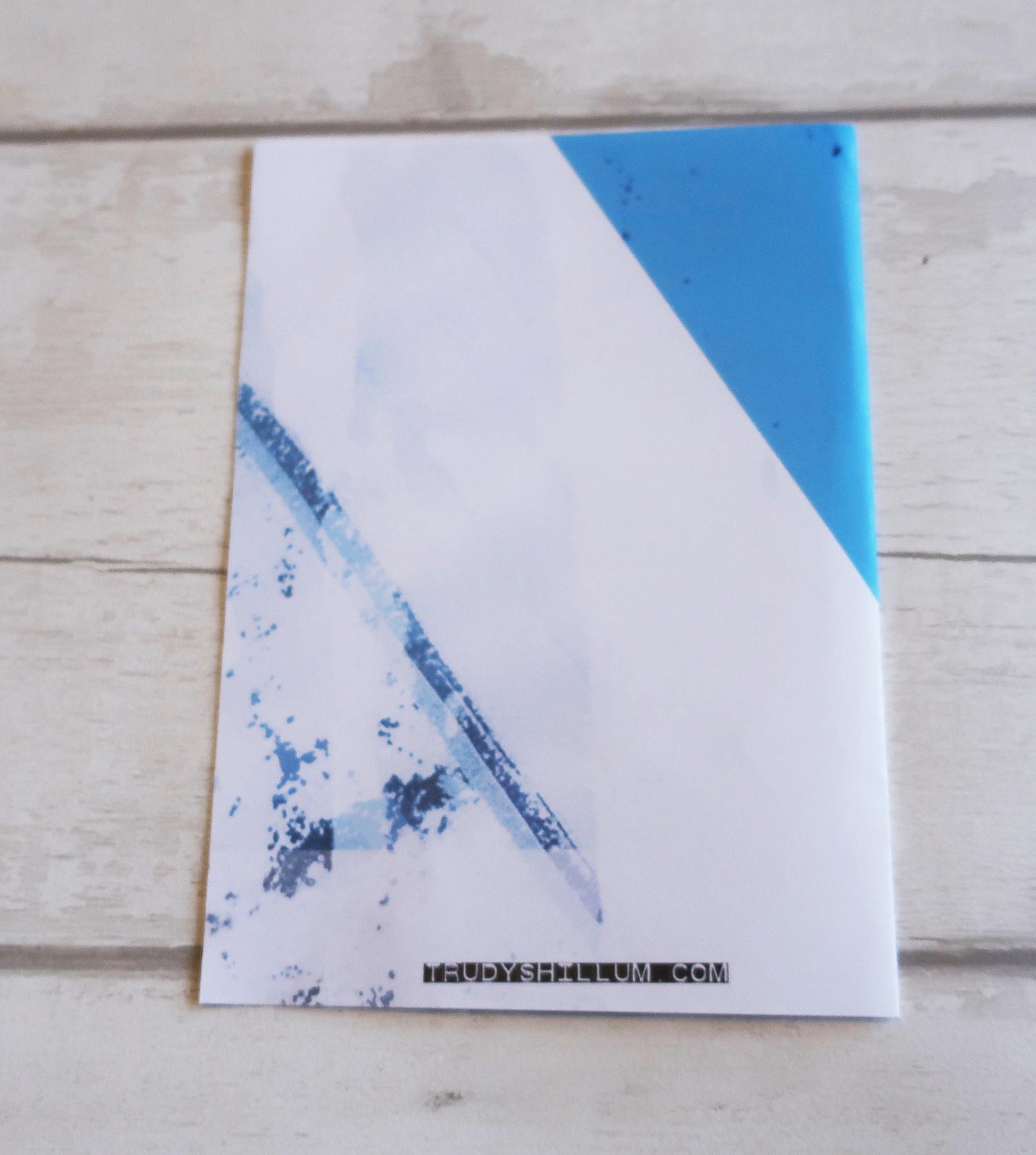 Card with blue abstract design on a wooden surface