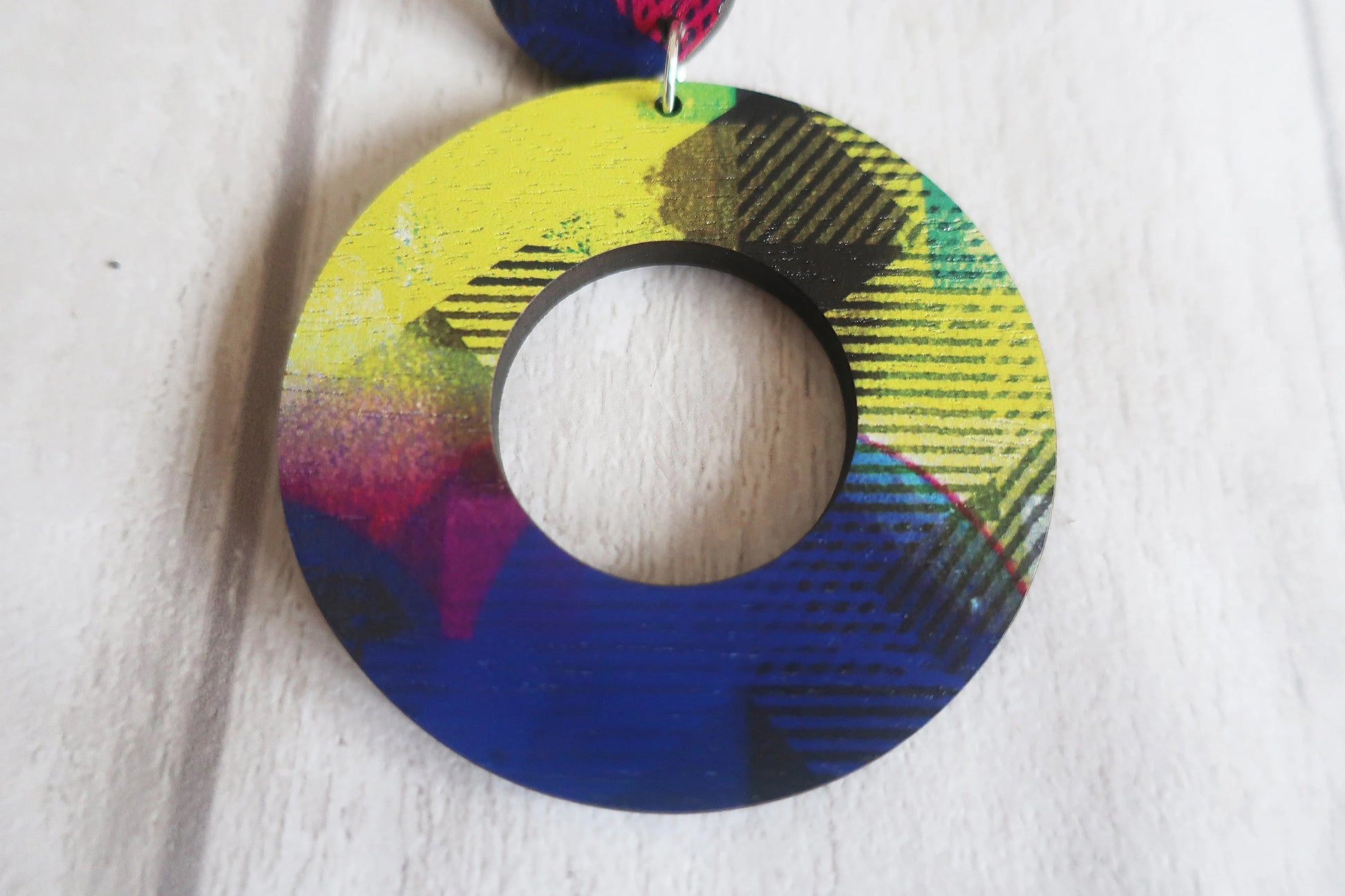 Colorful circular earring on a white background